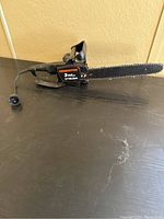 Side profile of the Remington electric chainsaw showing overall shape and size with cord plug visible.