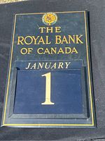 Close-up of calendar board showing Royal Bank of Canada logo, January month card and the date card showing number 1.