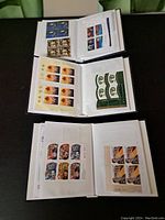 Open album showing multiple pages with various Canadian stamp sheets