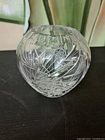Photo of the crystal vase showing the cut pinwheel and leaf patterns on the rounded body.