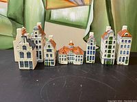 Front view of the seven hand painted ceramic Dutch style houses with various heights and shapes showing detailed windows and roofs.