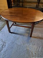 Side view of the oval wooden coffee table showing smooth finish and leg structure.