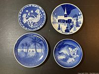 Overhead view of all four Royal Copenhagen vintage decorative plates showing different blue and white designs and year markings.
