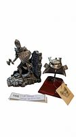 The full lot with knight bookend and separate samurai helmet miniature displayed on wooden stand with metal support and tag.