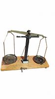 Full view of the vintage balance scale showing two metal pans suspended on a beam supported by a wooden base.