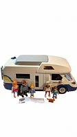 Exterior side view of the camper van with family figures and accessories displayed in front of it