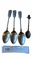 Four sterling silver spoons displayed, three large and one smaller ornate spoon, on white background.