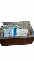 Primitive wood crate filled with vintage postcards, photos, and paper ephemera