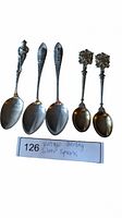 All five vintage sterling silver spoons displayed with handles upright, showing different designs and shapes.