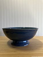 Side view of blue ceramic bowl showing the shape, color, and size.