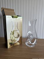 Carafe beside its box showing the shape and design of the glass carafe with spiral inside.