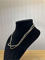 Two seed bead necklaces displayed on black necklace bust, front view showing overall length and bead color.