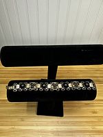 Front view of the gold colored bracelet with alternating large black onyx stones and butterfly-shaped segments with smaller black onyx stones.