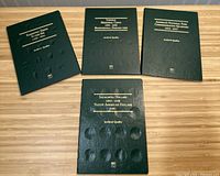 Four dark green coin albums with gold embossed lettering visible on covers for various U.S. coin series. Albums are archival quality and have coin indentations for coin placement. Surface shows some minor wear.