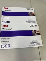 Photo showing two unopened packs of 3M Wetordry abrasive sheets, each pack contains 50 sheets of 1500 grit sanding paper sized 140 mm x 228 mm.