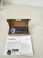Opened cardboard box featuring Lamphus SoundAlert 100W electric air horn amplifier unit, wiring, and instruction sheet.
