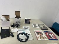 Overview of lot items including the aroma diffuser, HDMI cables, DVDs, charger, and accessories placed on a table.