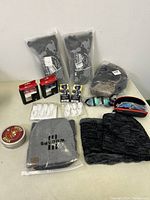 Lot overview showing sports glasses, winter hats, gloves and accessories on table