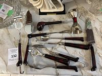 Overview of golf themed bar accessory tools with golf club shaped handles and silver metal parts arranged on marble surface