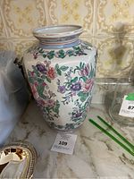 Photo of the full vase showing detailed hand-painted floral design and gold rim.