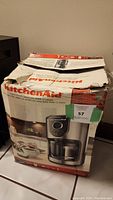 Photo of the front side of the KitchenAid coffee maker box showing the coffee maker image and box condition.
