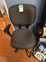 Front view of the office chair showing checkered upholstery and armrests.