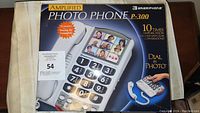 Front of original product box showing image of Ameriphone Amplified Photo Phone P-300 with photo dial buttons and product name.