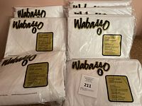 Seven white fitted sheets still in the original bag with Wabasso branding and labels visible.