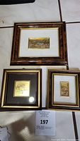 Three framed miniature paintings arranged on a tile floor, showing overall condition and details of each artwork.