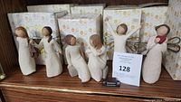 Six Willow Tree figurines display with original boxes in background.