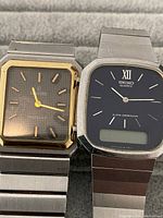 Front view of two vintage watches showing rectangular faces, one Seiko Quartz and one Mariner SG with gold-tone bezel