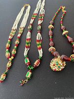 Three necklaces displayed flat showing full length and decorative details.