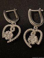 Front view of the sterling silver heart-shaped cubic zirconia earrings showing the kidney clasp and dangling heart design.