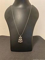 Full necklace on display stand showing pendant and chain.