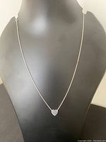 Sterling silver necklace displayed on a mannequin bust showing the heart pendant centered on the chain.