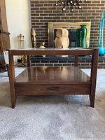 Front view of the wooden coffee table showing the bottom drawer and the frame.