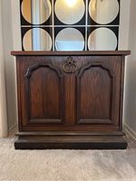 Front view of mid-century Lane record cabinet with paneled double doors and brass ring pull handles.