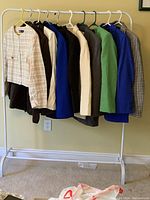 Photo showing 10 women's jackets hanging on a rack in various colors and patterns