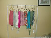 Full view of 10 pairs of ZARA women's pants hanging on rack, showing various colors and patterns.