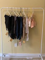 Full view of all pants and bras hanging on rack, showing colors and tags.