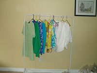 Image of all 10 tops hanging on a rack, showing variety of colors and styles.