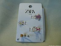 Front view of 4 ZARA hairpins attached to original card, showing decorative designs: daisy flower, butterfly, purple figure, flamingo.
