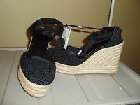 Pair of black ankle wrap wedge shoes from ZARA with tags attached, displayed side by side to show the design and wedge heel.
