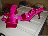Pair of bright pink satin ZARA high-heeled shoes showing open square toes, wide ribbon straps and ribbon ankle detail, heels approximately 3-4 inches high.