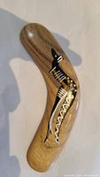 Image of the hand-painted wooden boomerang showing detailed indigenous-style artwork on natural wood surface.