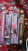 Four Krause Publications toy identification and price guide books arranged vertically with spines facing up, visible years 1995, 1996, 1998, and 2003 editions, on a patterned carpet.