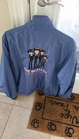 Back of blue windbreaker showing large animated Beatles group graphic and The Beatles text.