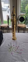 Full view of gold lacquered soprano saxophone on table