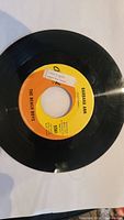 Photo of the vintage 45 RPM vinyl record The Beach Boys 'Barbara Ann' with orange and yellow Columbia label, showing condition and label stickers.