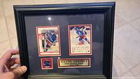 Framed display holding two hockey cards and a blue New York Rangers pin, representing Wayne Gretzky.